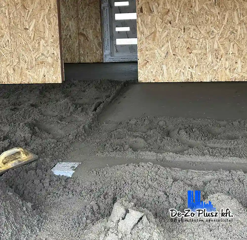 Frissen terített estrich beton beltéri helyiségben, kivitelezés közben, nyári aljzatkészítéshez
